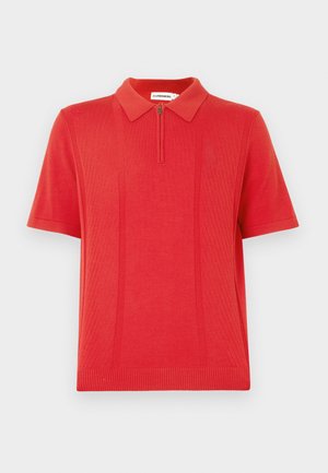 Rød kortermet poloshirt laget av strikket stoff, med glidelåslukking foran og teksturert vertikal ribbestruktur langs sidene.