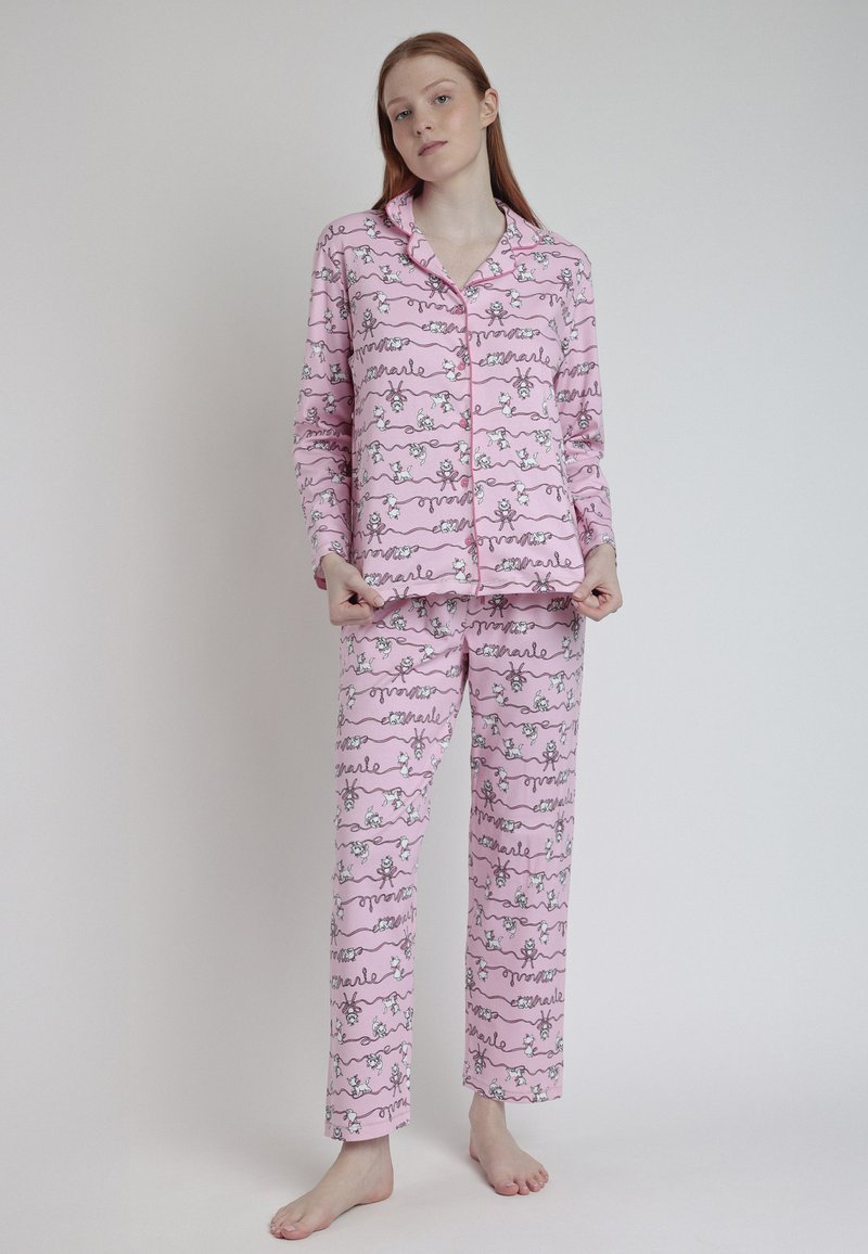 Conjunto de pijama rosa con mangas largas y pantalones, que presenta un patrón divertido de figuras y palabras en blanco y negro. Tela suave con una textura lisa.