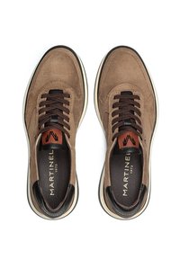 Zapatillas de ante marrón con cordones marrones oscuros, detalles en cuero negro y una suela blanca. Presentan una plantilla con marca y costuras en contraste.
