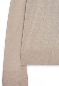 Villatuinen beige, jossa on pyöreä kaula-aukko, ribatut hihansuut ja hieman vaaleampi ribattu helma lisätekstuurin saamiseksi.