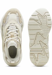 Zapatillas deportivas beige que presentan una combinación de materiales de malla y ante, suela texturizada, diseño con cordones y un logotipo prominente de la marca en la lengüeta.