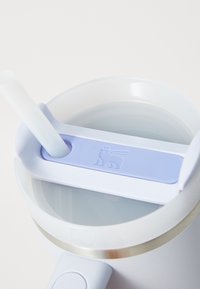 Transparent water bottle with a light blue lid and straw, featuring a logo of a crowned lion on the lid. Circular shape and smooth texture.