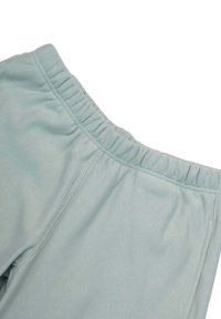 Pantaloni jogger verde menta chiaro con una texture morbida, vita elastica e cuciture piatte. Il tessuto appare liscio con motivi visibili minimi.