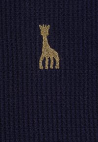 Tessuto a coste di un blu navy scuro con un design di giraffa ricamato in oro. La texture è morbida e lavorata a maglia, aggiungendo profondità al motivo.