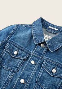 Giacca di jeans in cotone organico blu scuro con chiusura a bottoni, due tasche sul petto e colletto classico. Presenta bottoni color argento.