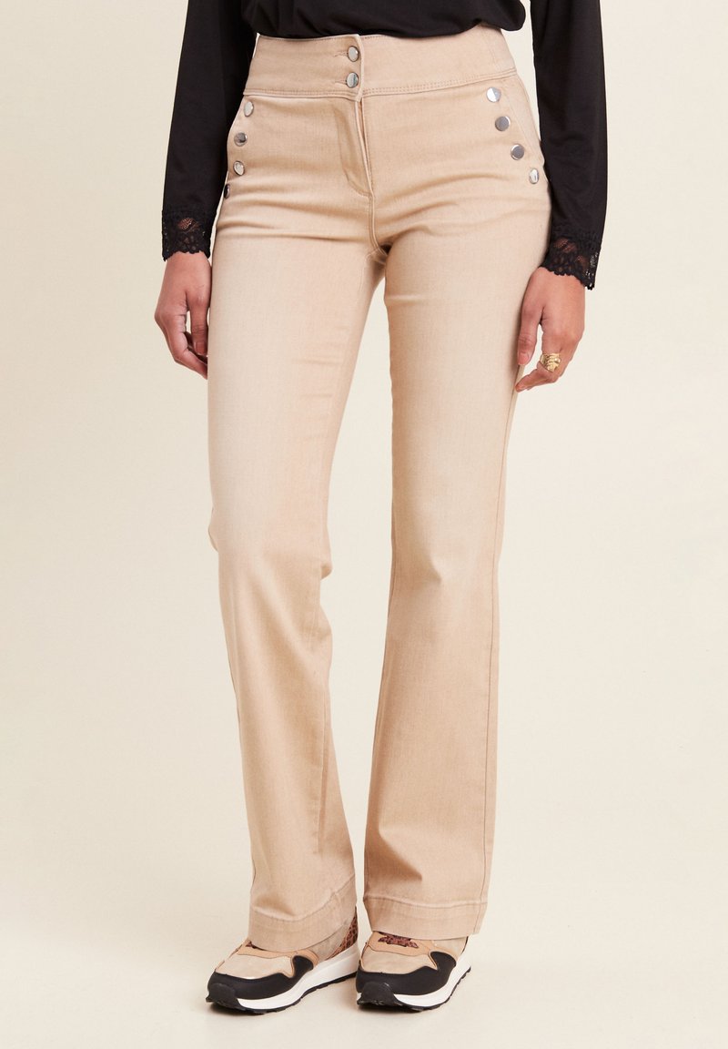 Jeans beige a palazzo con bottoni metallici lungo il lato, design a vita alta e una texture denim liscia e leggera.