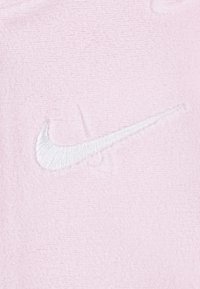 Roza flis tkanina z teksturirano površino. Na voljo je z vezenim belim logotipom Nike swoosh. Preprost dizajn, brez dodatnih vzorcev ali akcentov.