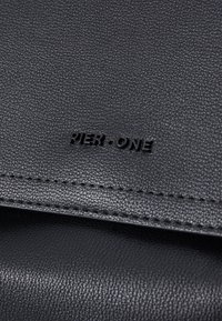 Black leather wallet with textured surface, featuring embossed 'PIER ONE' logo, visible stitching along the edge, and a smooth finish.