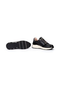 Zapatillas deportivas negras con una textura suave, que cuentan con un cuello acolchado, suela blanca y cordones con diseño. Incluyen una suela exterior de goma contrastante.