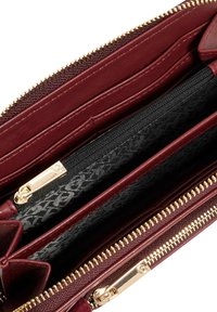 Burgundy leather wallet with a zip closure, featuring a black patterned interior, multiple card slots, and a gold-tone zipper.