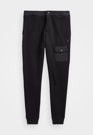 Pantalon de jogging noir fuselé avec une poche cargo boutonnée sur la cuisse droite et des poignets côtelés aux chevilles.