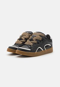 Zwarte sneakers met een gestructureerde leren bovenkant, witte accenten en opvallende veter in visgraatpatroon. Rubberen gumzool.