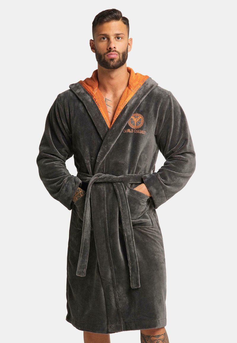 Grijs, gestructureerd badjasje met een oranje voering in de capuchon, een ceintuur in de taille en voorzakken. Heeft een logo op de borst geborduurd in het oranje.
