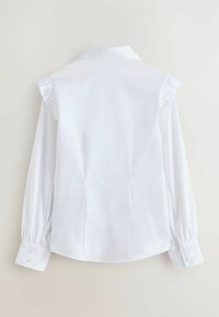 Blusa bianca a maniche lunghe con design delle spalle arricciato, caratterizzata da un colletto classico e polsini con bottone, con una trama liscia e una vestibilità sartoriale.