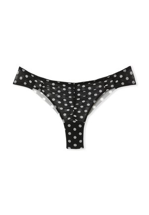 String noir à pois fabriqué en tissu transparent, avec des pois blancs, une taille fine et un design en forme de V à l'arrière.