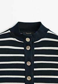 Maglione a righe orizzontali blu navy e bianco con colletto a costine e una fila verticale di quattro bottoni decorativi argentati.