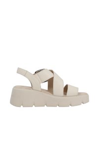Sandales plateformes beige clair fabriquées en matériau doux, avec de larges brides entrecroisées, une boucle réglable et une semelle texturée.