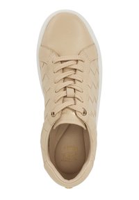 Basket en cuir beige avec un design en chevrons texturé, bout rond et semelle plate en caoutchouc blanc. Dispose de lacets en tissu et d'œillets en ton or.