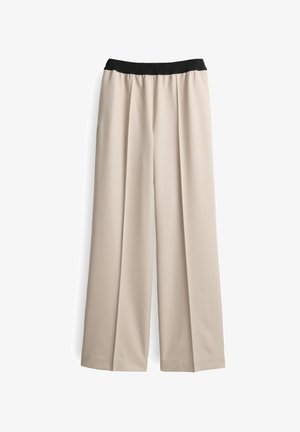 Beige, wide-leg trousers with a black elastic waistband. Made from a smooth fabric with a flowing drape and crisp pleats down the front.