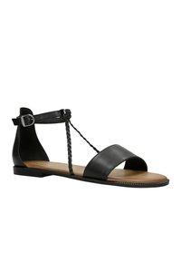 Zwarte leren sandaal met een open teen, brede voorkantband, gevlochten details en een verstelbare enkelband met een metalen gesp. Platte zool.