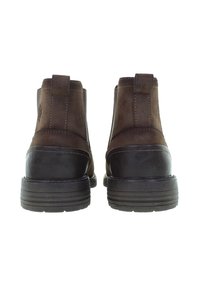 Hnědé semišové kotníkové boty s černou gumovou podrážkou, s elastickými postranními panely a detailem centrálního švu, navržené pro snadné obouvání.