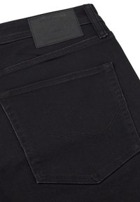 Černé denimové džíny s hladkým povrchem, vybavené černou koženou nášivkou a zadní kapsou s klasickým švem.