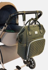 Bolsa para pañales verde oscuro acolchada con asas dobles y herrajes plateados, sujeta a un cochecito, con un bolsillo frontal con cremallera y compartimentos laterales.