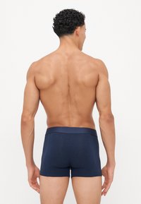 Marineblaue Boxershorts aus weichem Stoff, mit einem glatten Bund. Das Design ist enganliegend und zeigt einen minimalistischen Stil.