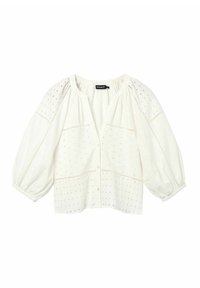 Blusa bianca con maniche corte a puffo. Tessuto texture con motivi a occhio di pernice e una leggera impuntura decorativa. Chiusura con bottoni frontali.
