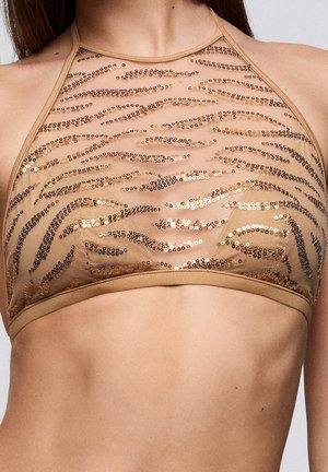 Halterbeha in tan met paillettenversiering en een doorschijnende afwerking, met een golvend patroon in goud- en bruintinten en een zachte elastische band aan de onderkant.