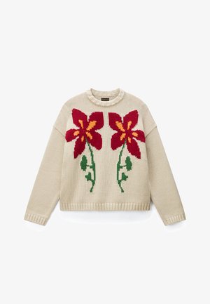 Beżowy sweter na drutach z dwoma dużymi czerwonymi kwiatami z żółtymi środkami i zielonymi łodygami z przodu, długimi rękawami i prążkowanymi brzegami.