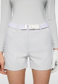 Ljust gråa sportshorts med rak front, sidofickor och ett vitt vävt bälte med en rektangulär metalspänne och loopsdetaljer.