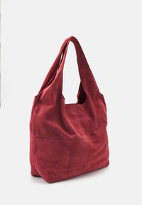 Rote Wildleder-Tote mit offenem Oberteil, bestehend aus weichem, strukturiertem Material und zwei langen Tragegriffen für müheloses Tragen. Sanft nach unten gefallene Form.