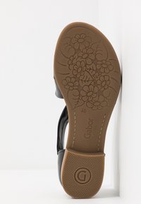 Semelle de chaussure noire avec motif floral, taille 4½, marque "Gabor" et "Made in Portugal" marqués sur la semelle beige.