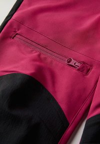 Kangas fuksia sisältää vetoketjullisen taskun, jonka reunassa on musta kohta. Tekstuurin pinta näyttää sileältä ja hieman kiiltävältä.