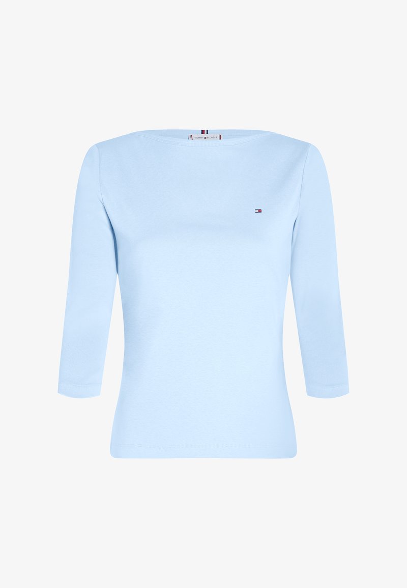 Light blue long-sleeve top in soft cotton, featuring a round neckline and small logo embellishment on the chest. Smooth texture, fitted design.