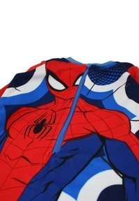 Grenouillère thématique Spider-Man rouge et bleue avec fermeture éclair, impression graphique du torse de Spider-Man et accents bleus. Texture de tissu lisse.