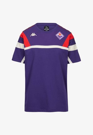 Maglietta sportiva a maniche corte viola con strisce rosse e bianche, logo Kappa sul petto a destra e stemma del club di calcio Fiorentina sul petto a sinistra.