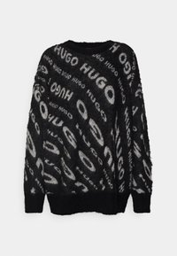 Zwart- en grijskleurige gebreide trui met een patroon van herhaalde logo's. Losse pasvorm met een ronde hals en lange mouwen. Zachte textuur.