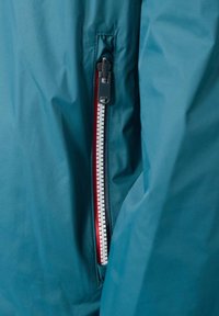 Blaue wasserdichte Jacke mit einem Reißverschluss auf der linken Seite, roten Akzenten und einer strukturierten Oberfläche. Der Reißverschluss verfügt über einen schwarzen Zuglaschen für leichtes Öffnen.