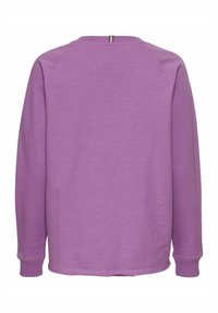 Fioletowa bluza z długim rękawem o miękkiej teksturze, okrągłym dekolcie i ściągaczach. Posiada prosty tył i minimalistyczny design.