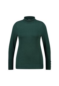 Donkergroene coltrui gemaakt van zacht gebreid materiaal. Heeft lange mouwen met knoopaccenten bij de manchetten en een getailleerd silhouet.