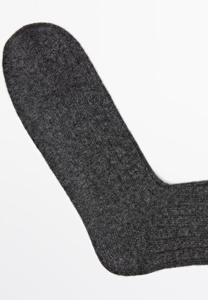 Gray wool sock with ribbed texture, rounded toe, and smooth woven surface, showcasing a solid dark color throughout.