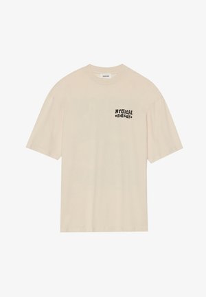 Kermanvärinen puuvillapaita, jossa on lyhyet hihat ja rento leikkaus. Vasemmassa rinnassa on musta graafinen teksti "MYSTICAL ENERGY".