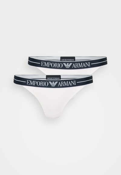 Baltas tanga apakšveļa ar tumši zilu elastīgu jostu, kurā ir "Emporio Armani" logo. Gluda auduma struktūra ar vienkāršu dizainu.