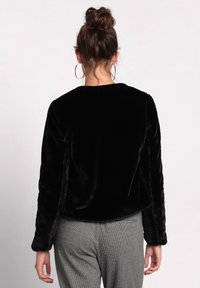 Black faux fur jacket with a round neckline and long sleeves, featuring a smooth texture and a relaxed fit. Back view only.