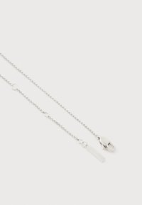 Λεπτό ασημένιο κολιέ με αλυσίδα, κούμπωμα με καβούρι και μικρή ορθογώνια ετικέτα, σε λευκό φόντο.