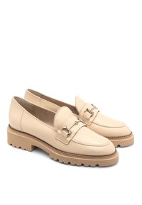 Mocassini in pelle beige con finitura testurizzata, caratterizzati da dettagli con fibbia metallica e una suola in gomma chunky con bordo seghettato.