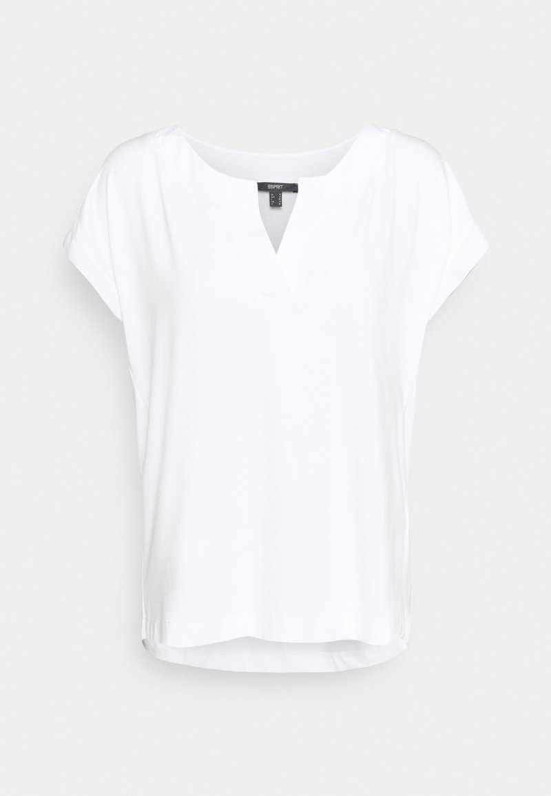 Blouse blanche à manches courtes avec un décolleté en V et une coupe fluide et décontractée, présentée sur un fond uni.