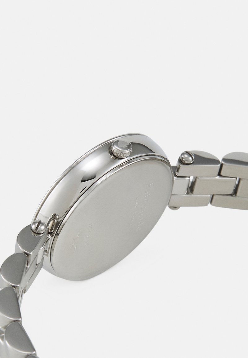 Orologio in metallo argento con cassa rotonda liscia, corona di carica e bracciale a maglie con finitura lucida. Il retro è piatto e privo di decorazioni.